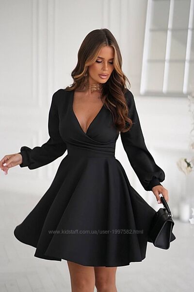 Елегантна коротка сукня з довгими рукавами та глибоким V-подібним вирізом. 
